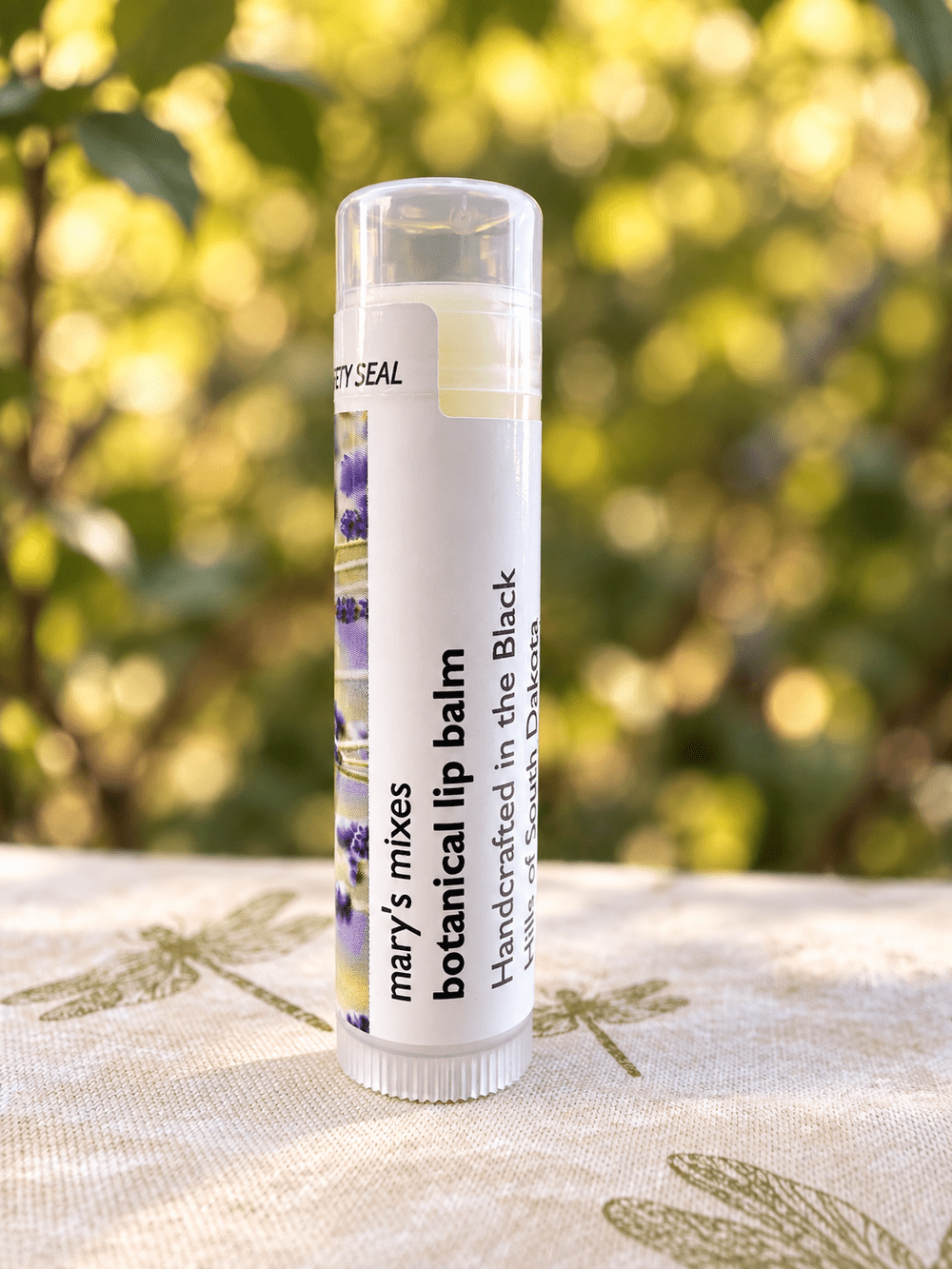 Mary’s Mixes Botanical Lip Balm standing among garden greenery